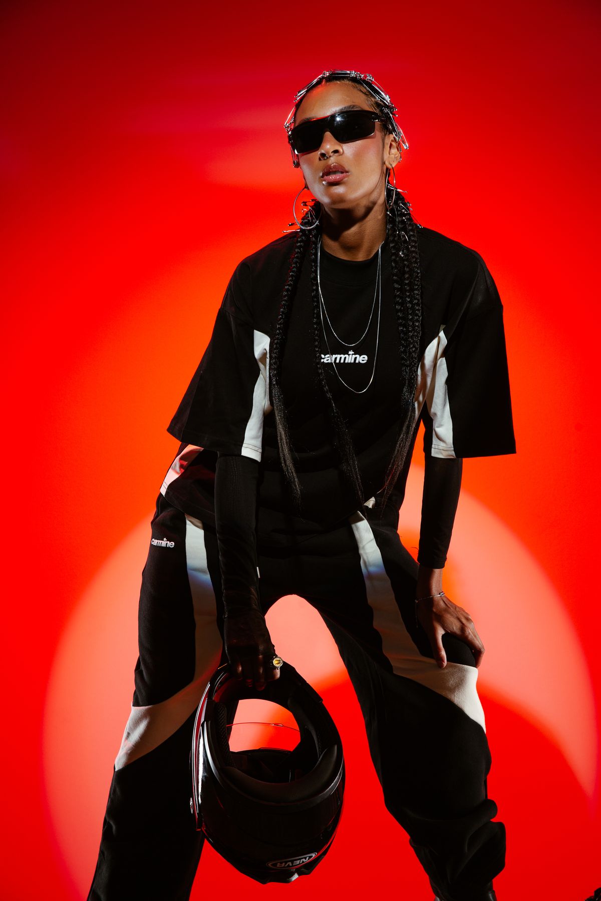 Model in moto trousers holding a helmet