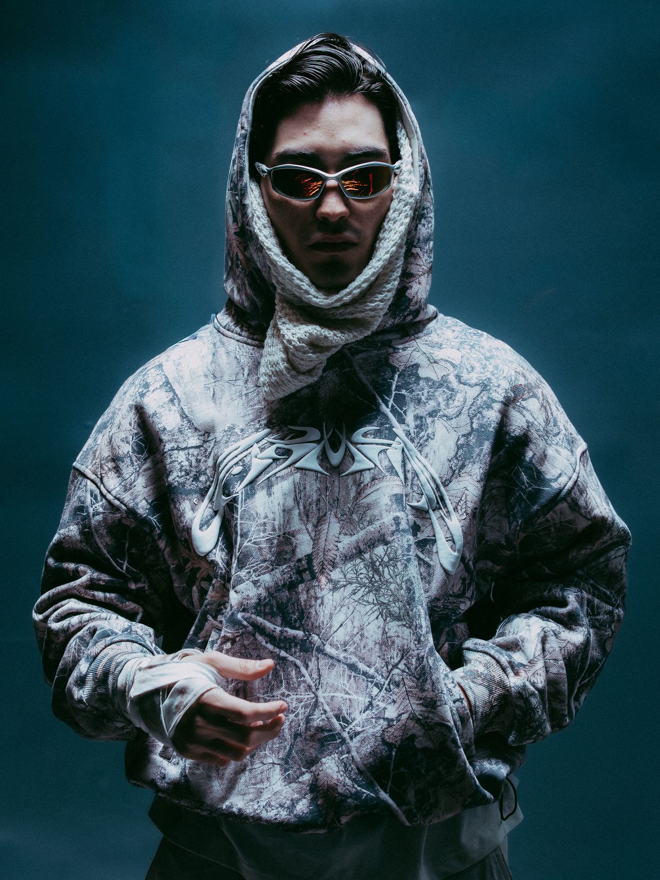 Model in a hooded camouflage top