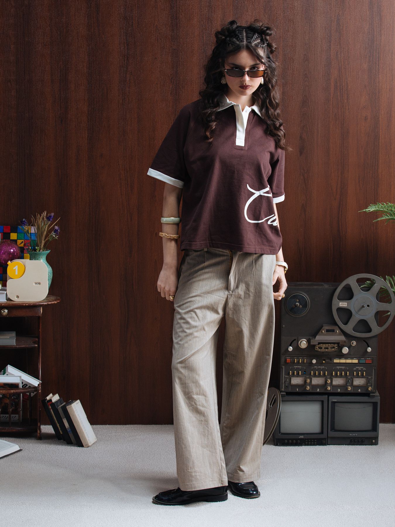Model in a brown polo and wide trousers